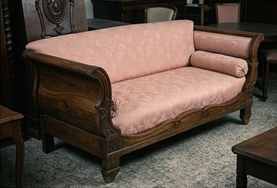 Divano Antico Biedermeier in Noce e Tessuto Rosa Cipria Raffinato divano antico d'epoca XIX secolo in stile Biedermeier a barca, realizzato con una solida e sagomata struttura in pregiato legno di noce dalle calde sfumature naturali. Il mobile si caratterizza per maestosi braccioli ricurvi a voluta con scanalature intagliate, fascia inferiore a onda e piedi squadrati a plinto. Seduta e schienale sono finemente imbottiti e rivestiti in tessuto damascato rosa cipria a motivi floreali, completati da due eleganti cuscini cilindrici coordinati con nappe. Conservato in ottimo stato originale con autentica patina d'epoca e naturale craquelure sulla finitura del legno, costituisce un pezzo d'antiquariato di grande fascino e romanticismo, perfetto per impreziosire saloni, ingressi o zone notte sia classiche che moderne.